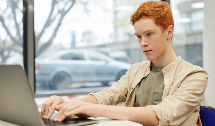 Boy Using Laptop in School