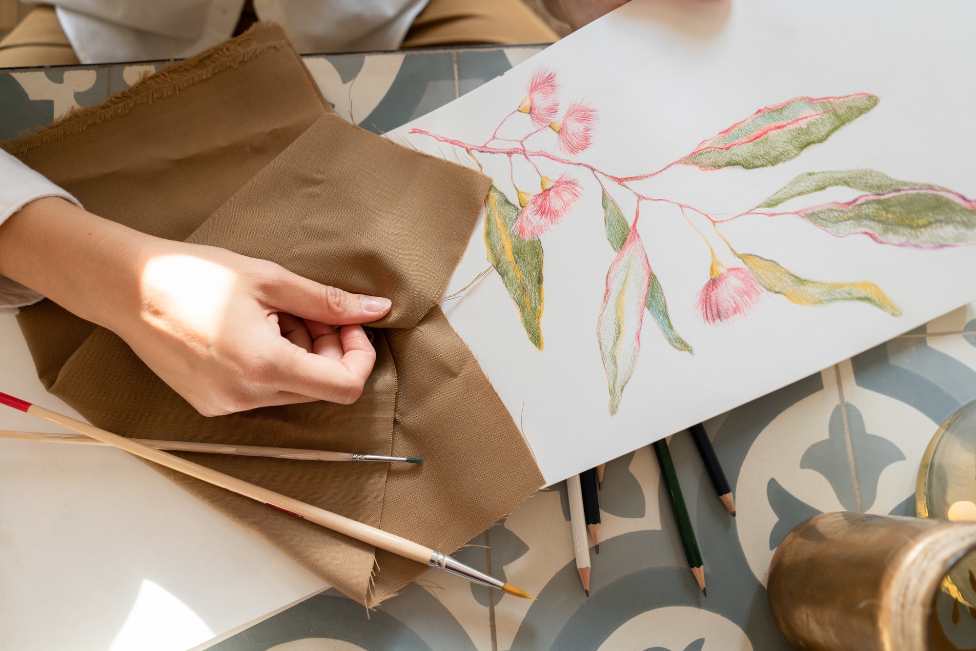 Woman at table near draw on paper and material